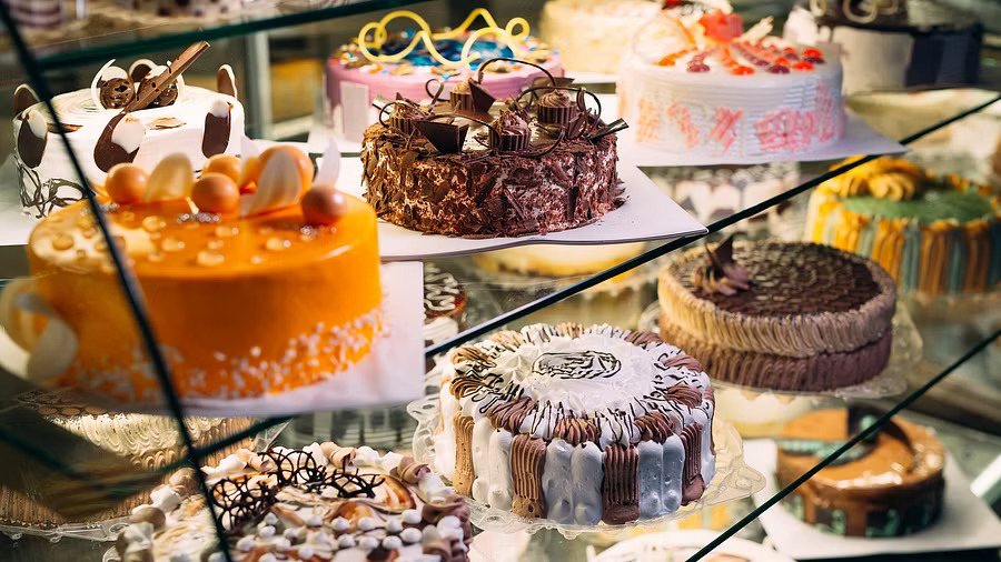 Pastry shop glass display with selection of cream or fruit cake